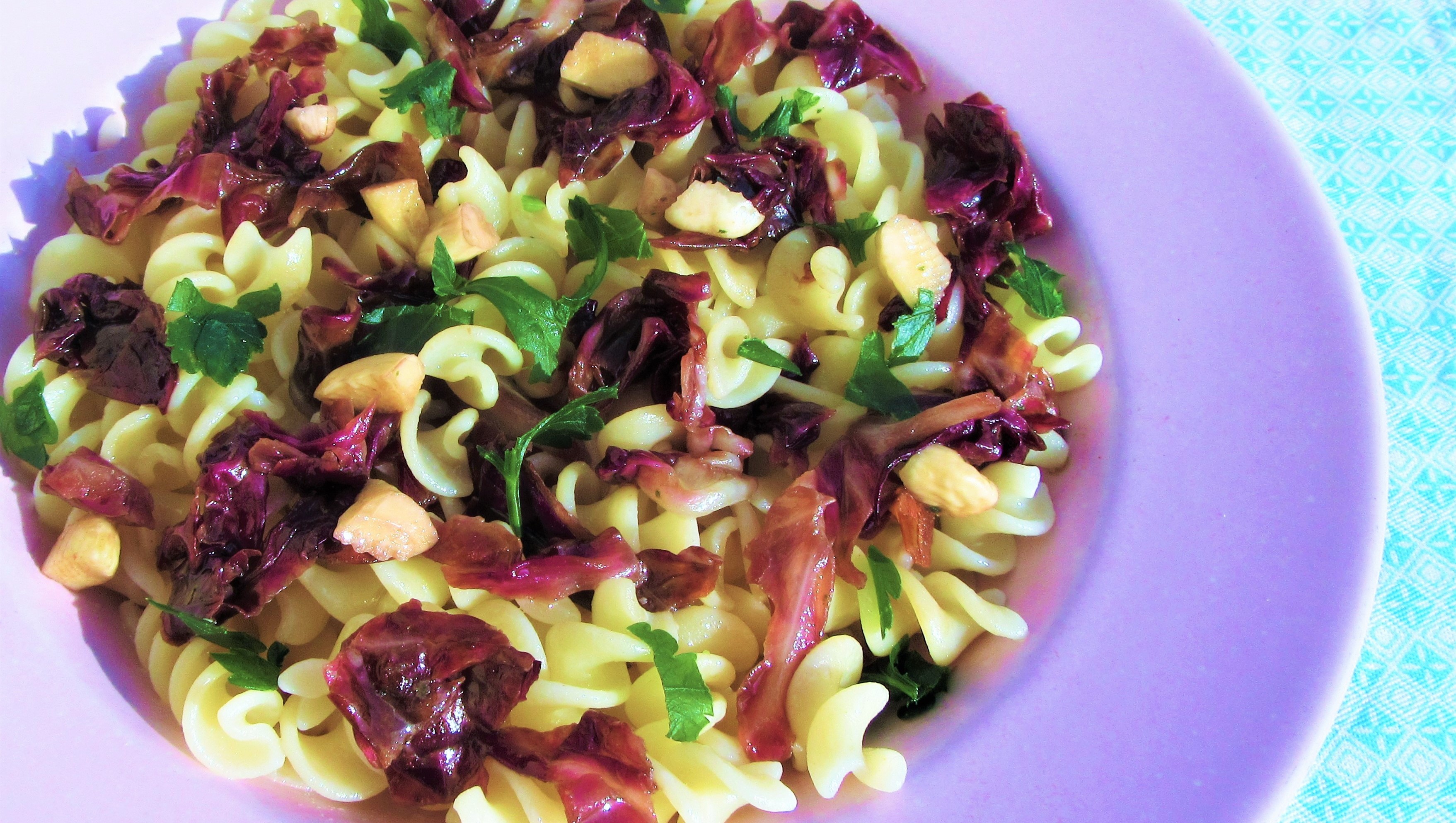 fusilli conditi con uno stuzzicante sugo a base di radicchio e mandorle