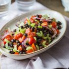 Insalata di ceci neri, sedano, pomodori e cipolle con olio alle erbe