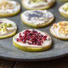 Tartine di pera e formaggio vegetale con frutta secca