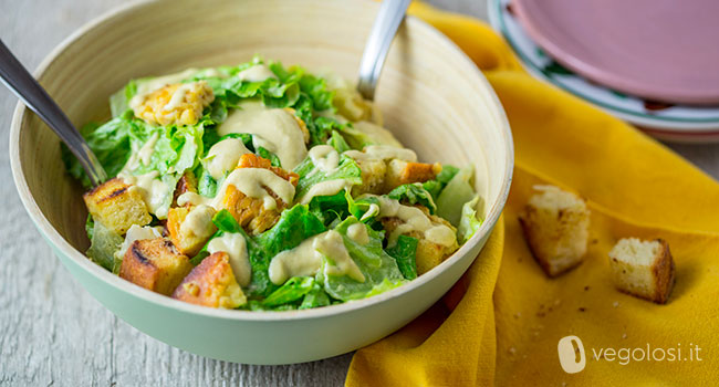 Caesar salad vegan con cubetti di tempeh e crostini di pane