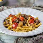 Strozzapreti con funghi cardoncelli, salsiccia vegan al primitivo e pomodorini