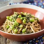 Spaghetti con taccole, edamame e pesto di olive e mandorle