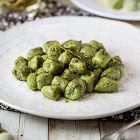 Gnocchi di piselli con burro alle erbe e semi di girasole